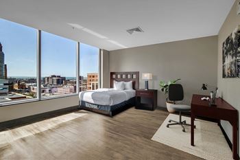 A bedroom with a large bed and a desk with a chair.